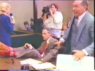 [defense attorney getting gun out of briefcase]